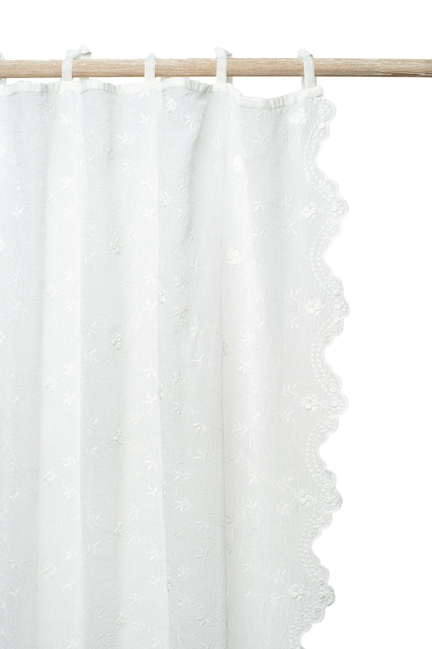 Close-up of delicate embroidery detail on a luxurious voile panel.